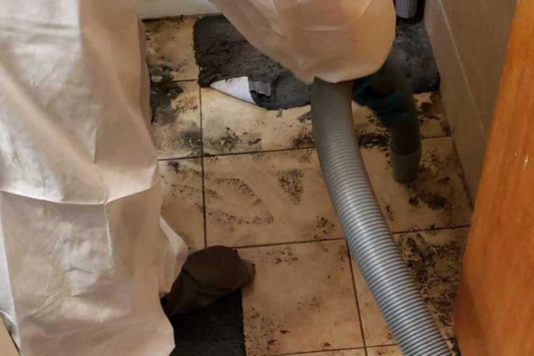 Restoration crew cleaning up sewage backup in home bathroom